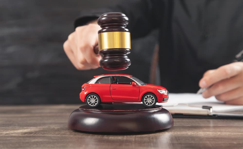 Man striking the gavel over car. Car auction.