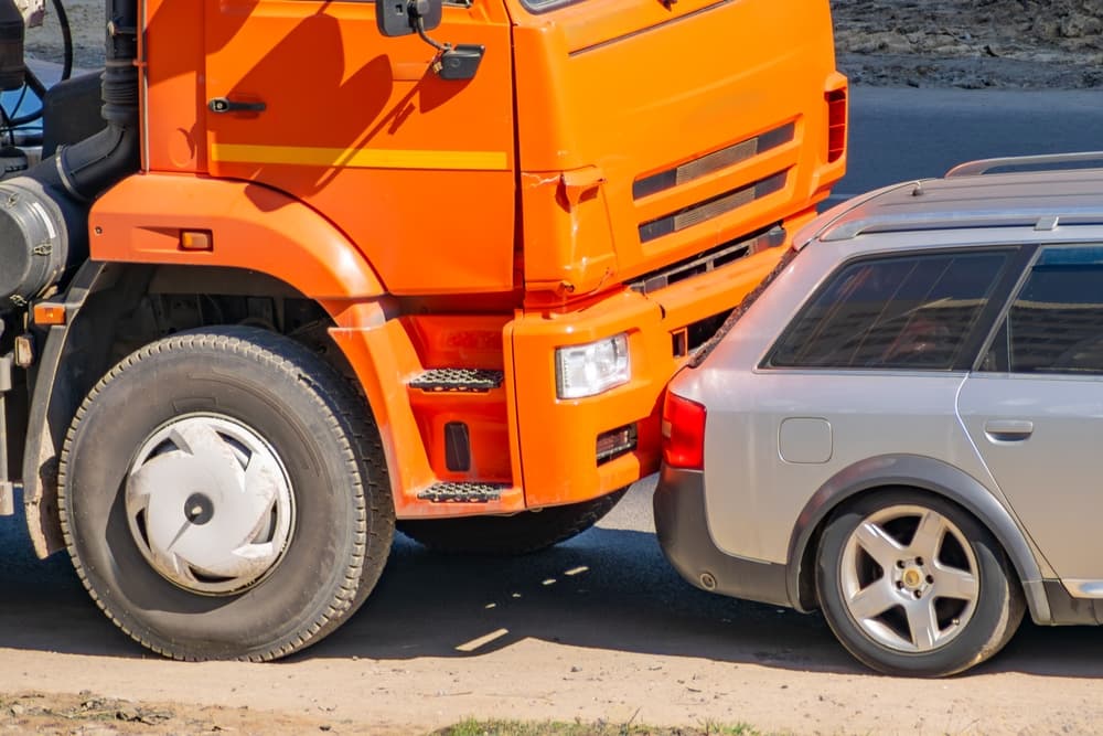 Accident between an orange truck and a passenger car.