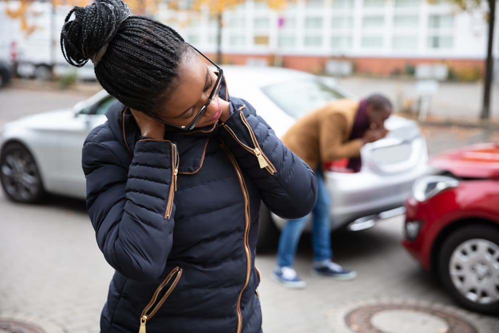 Woman holding her neck in pain after a car accident, illustrating physical suffering as evidence.