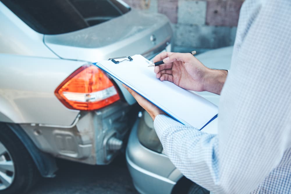 A man hands over documents related to a car crash accident.






