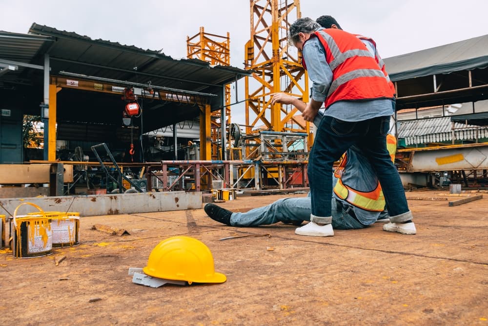 Construction site accident: Worker injured and down, requiring immediate medical attention. Urgent response needed for construction worker's safety.