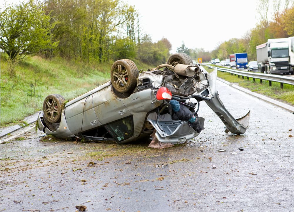 A car flipped upside down on a motorway after a crash.