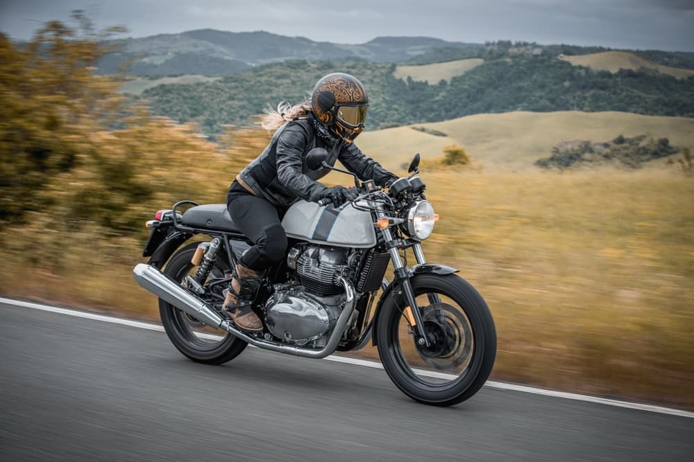 A woman riding a classic motorcycle, exuding confidence and style. 