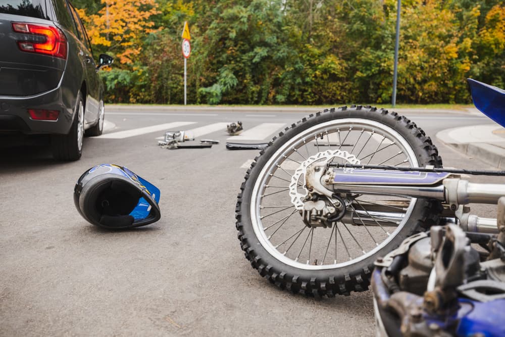 A motorcycle colliding with a car on a busy street.