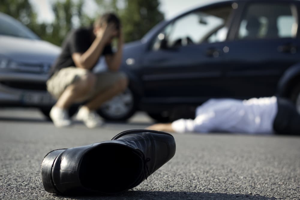 A car accident scene showing a damaged vehicle on the road, with emergency responders and law enforcement present, marking the aftermath of the collision.