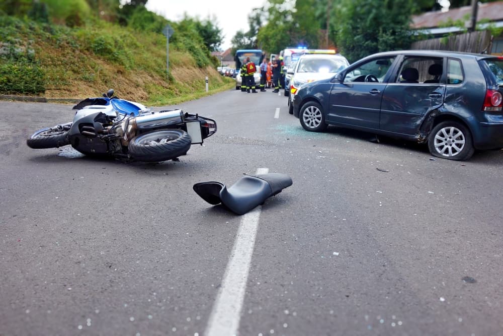 A serious motorcycle crash on a sunny day, highlighting driving hazards and vehicle collisions. Close-up view of the accident scene.