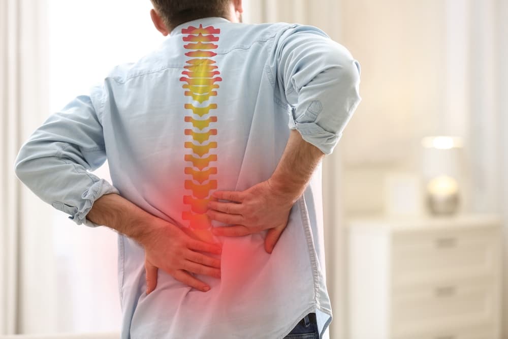 The image representing a man suffering from back pain at home after a serious accident. 