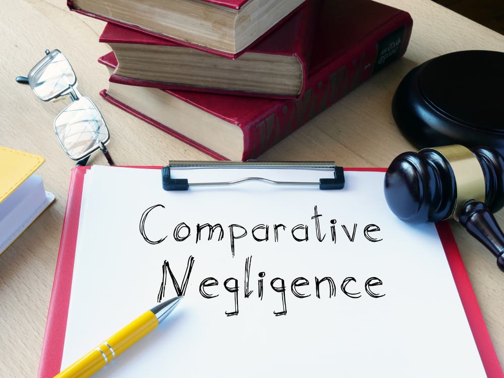 The concept of Comparative Negligence is illustrated in a conceptual photo using text to highlight shared fault between parties.