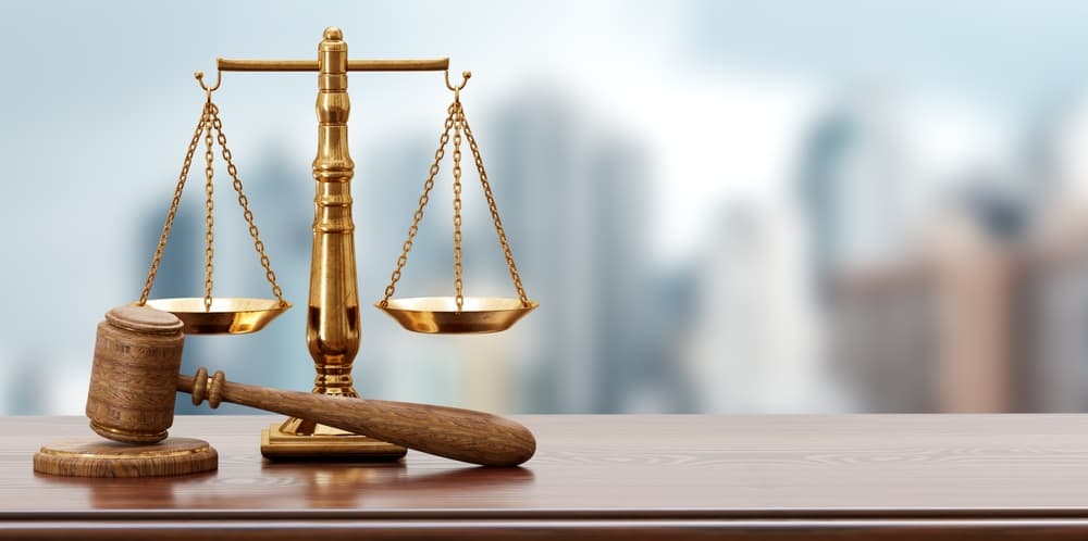 A background featuring legal scales and a judge's gavel, symbolizing the scales of justice. The image is designed for advertising legal services, with ample copy space for text. 