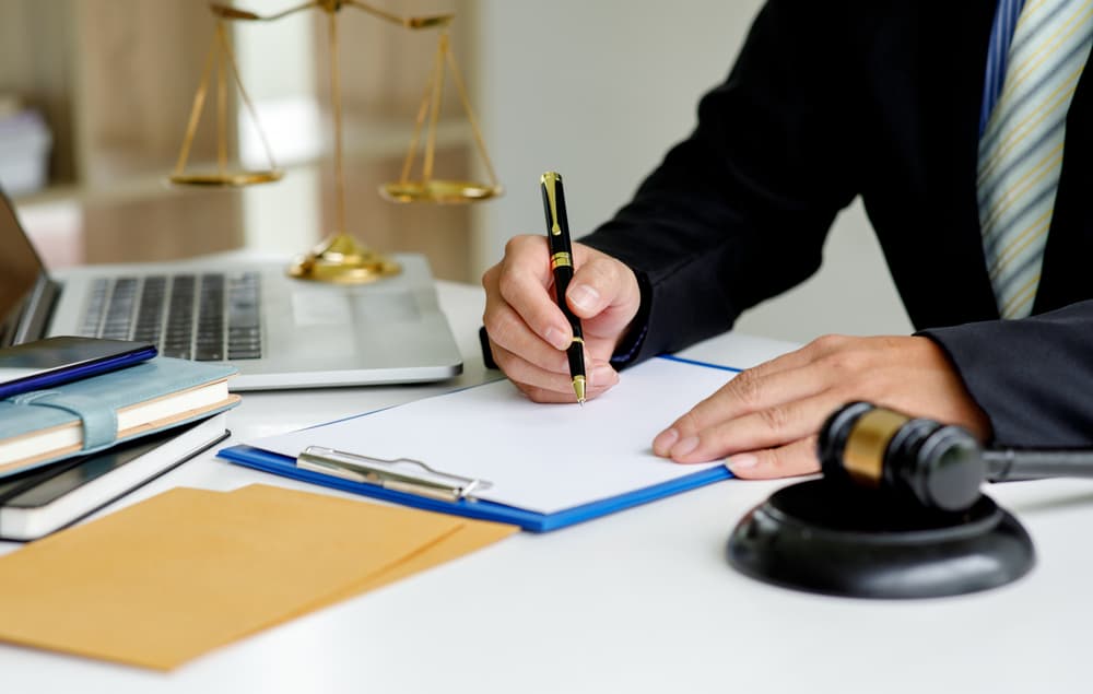 Close-up of a male lawyer working in an office, focused on legal documents, symbolizing justice, law, and legal advice.