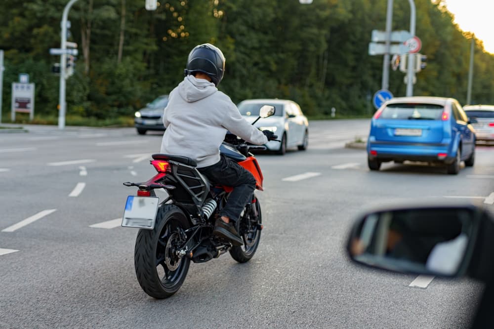 Motorway traffic flows with various vehicles, emphasizing that motorcyclists have the right to full lane usage.