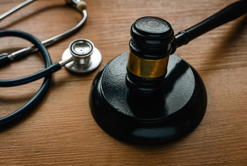 A gavel and stethoscope placed on a wooden table, symbolizing the intersection of law and medical issues in personal injury cases.