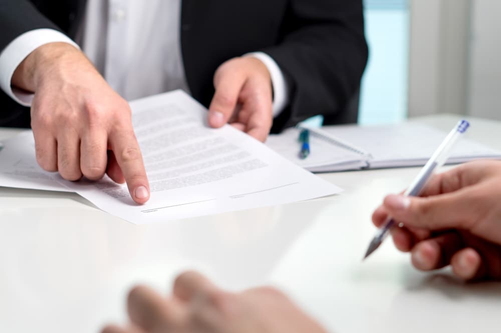 Signing a contract or agreement, a lawyer guiding a client to sign a document. Businessman and customer making a deal, or employee getting hired.