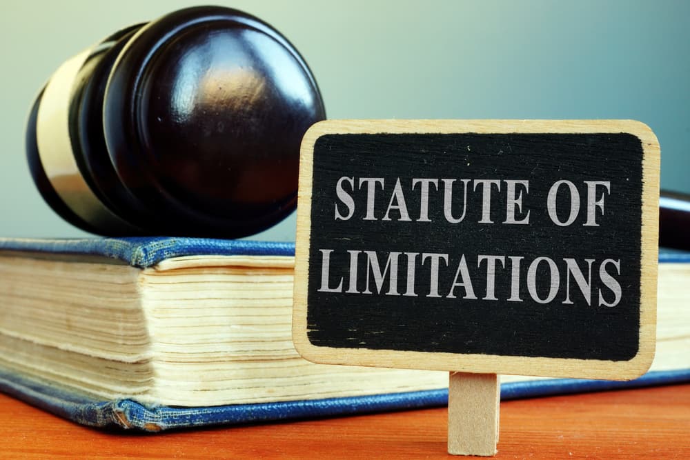 Statute of Limitations sign with a law book and gavel on a desk.